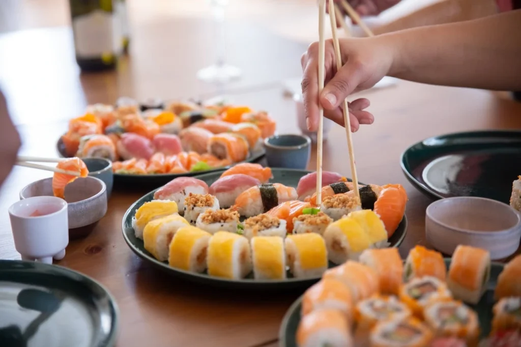 Holding Chopsticks With Japanese Food on the Plate
